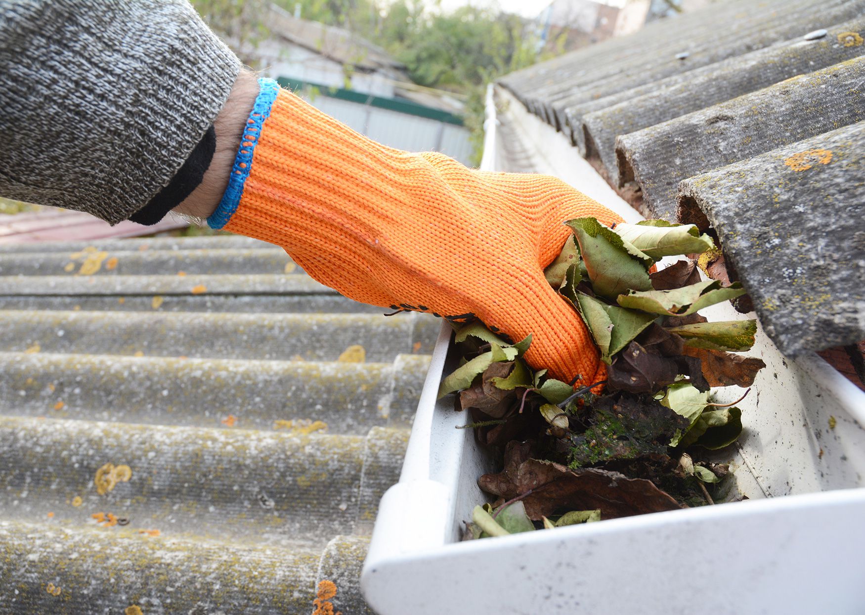 person-cleaning-out-roof-gutter-a7d758c873274953bd00f9dfd35b665d